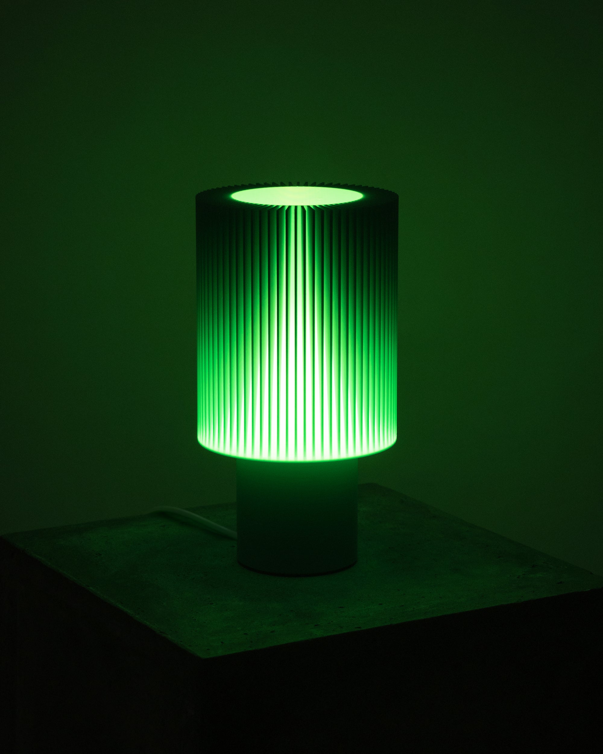 Lampe Iris Colors – Jade éteinte, imprimée en 3D, posée sur un socle en béton brut, vert vif au design nervuré saisissant.
