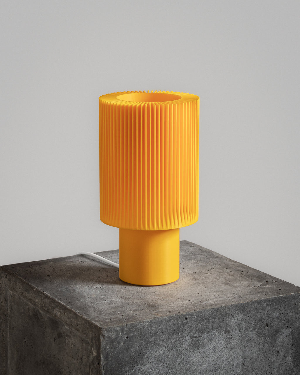 Lampe Iris Colors – Soufre éteinte, imprimée en 3D, posée sur un socle en béton brut, finition jaune solaire et design nervuré minimaliste.