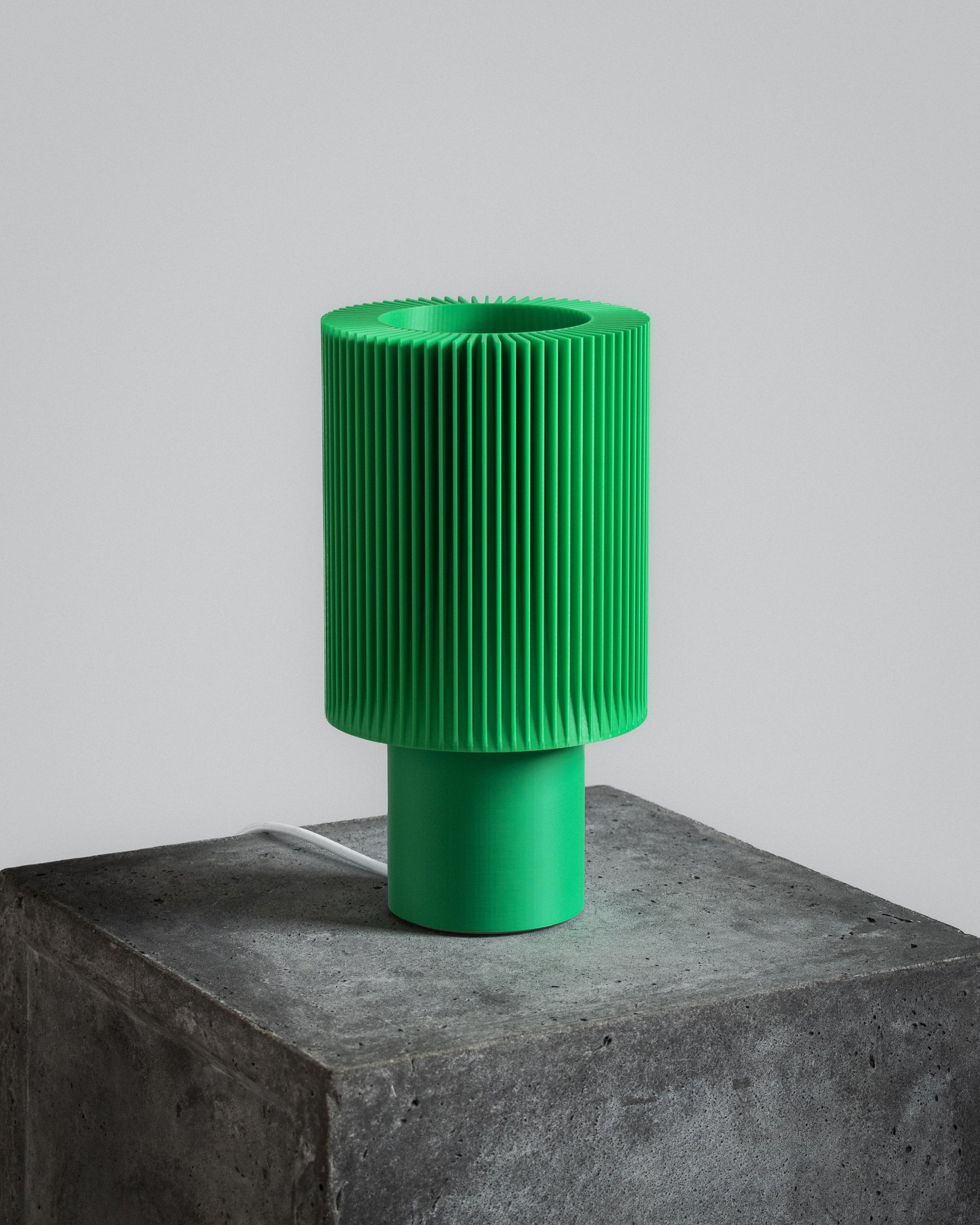 Lampe Iris Colors – Jade éteinte, imprimée en 3D, posée sur un socle en béton brut, vert vif au design nervuré saisissant.